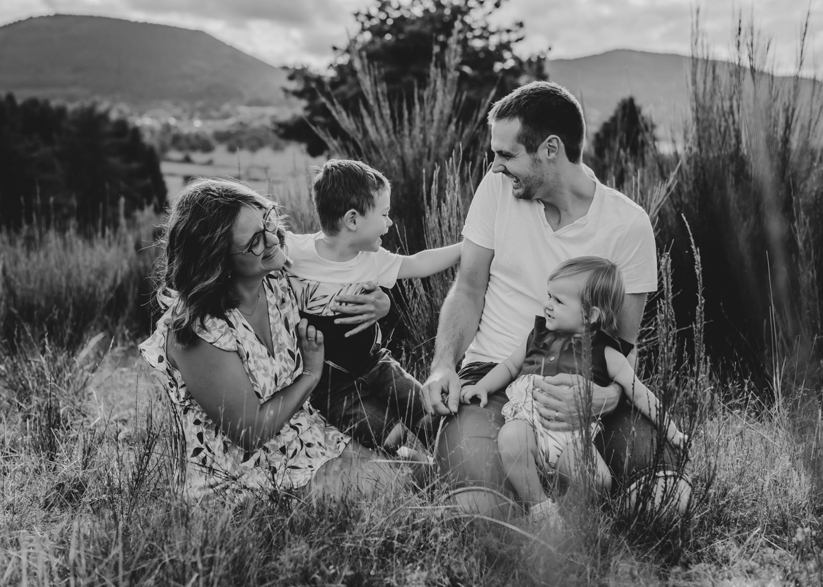 Portrait plein de complicité et de joie entre un couple et leur deux enfants lors d'une séance photo famille en Auvergne