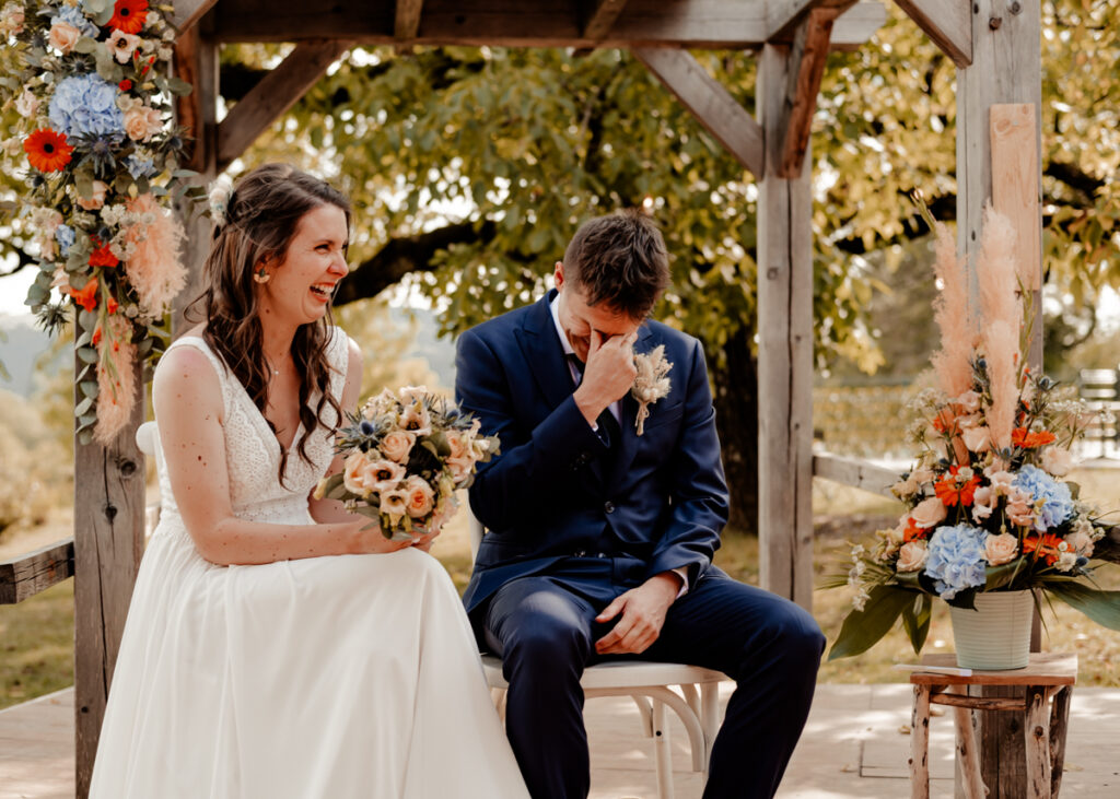 Portrait de mariés riant et pleurant pendant leur cérémonie laïque