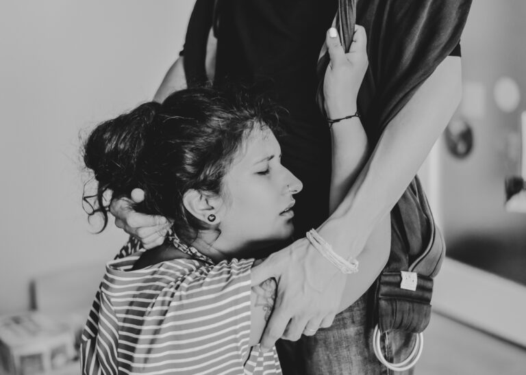 portrait d'une femme en train d'accoucher à domicile, se suspendant à un tissus porté par son mari