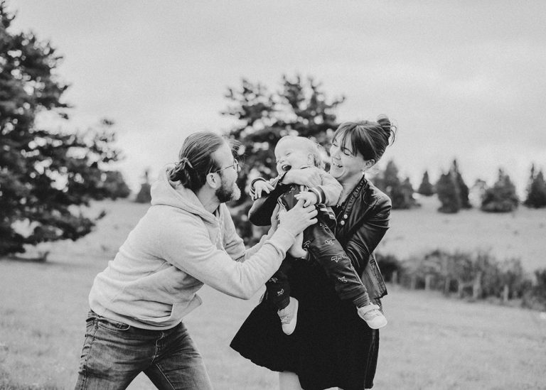 couple jouant avec leur enfant en pleine nature pendant une séance photo de famille près de Clermont-Ferrand en Auvergne