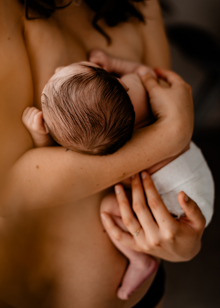bébé en peau à peau contre sa mère pendant une séance photo naissance intimiste
